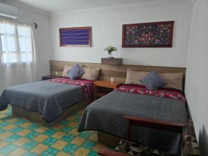 a bedroom with two beds and a table and a window at Casa en Centro histórico Alojamiento completo in Veracruz