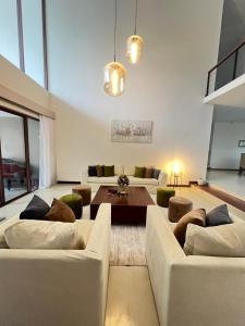 a living room with two couches and a table at Lumiere Villa, Kandy in Nugawela