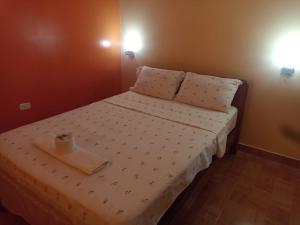 a small bedroom with a bed with a tray on it at Hostal Mitopampa in Lambayeque