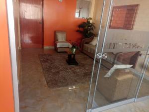 a living room with orange walls and a glass door at Hostal Mitopampa in Lambayeque