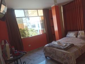 a bedroom with a bed and a large window at Hostal Mitopampa in Lambayeque +4 photos