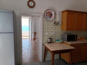 a kitchen with a refrigerator and a table with a microwave at Villetta Frasena in Santa Maria
