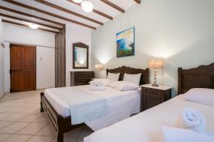 a bedroom with two beds and a mirror at Afrodite Hotel Apartments in Myrina
