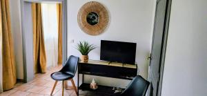 a room with two chairs and a desk with a television at La Cour d'Arblade in Arblade-le-Haut