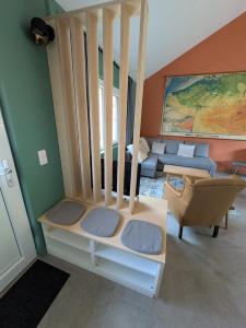 a room with a staircase with a chair and a couch at Au Bois Chantant in Somme-Leuze