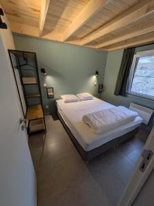 a bedroom with a large bed with a wooden ceiling at Au Bois Chantant in Somme-Leuze