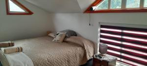 a small bedroom with a bed and a window at Casita Ancestral in Puerto Aisén