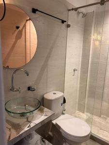 a bathroom with a toilet and a glass sink at aparta hotel del toro in Estación El Salto