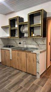 a kitchen with wooden cabinets and a counter top at aparta hotel del toro in Estación El Salto