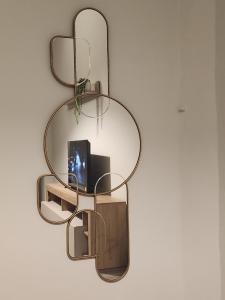 a glass shelf with a mirror on a wall at Casa di ringhiera 1 in Pinerolo +7 photos