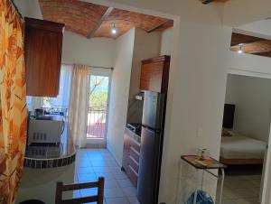 eine kleine Küche mit Kühlschrank und Fenster in der Unterkunft Playa de Carmil in Rincón de Guayabitos