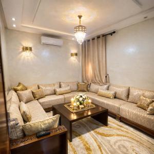a living room with a large couch and a table at Prime stay downtown Meknes in Meknès