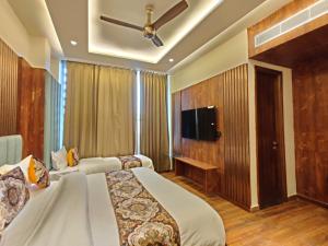 a hotel room with two beds and a flat screen tv at Hotel Absolut Comfort 500 MTR FROM GOLDEN TEMPLE in Amritsar +12 photos