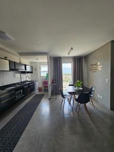 a kitchen and dining room with a table and chairs at Apto 83 in Itanhaém