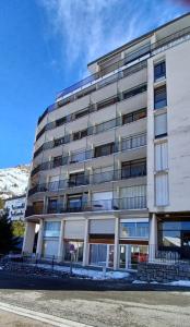 a large white building with snow on the ground at studio gourette pyrenees 4 pers pied des pistes in Gourette