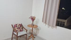 a vase of flowers on a table next to a chair at Hotel Central in Amparo