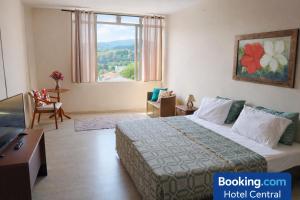 a hotel room with a bed and a large window at Hotel Central in Amparo