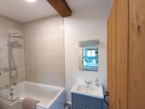 a bathroom with a tub and a sink and a shower at 2 Bed in Bishops Nympton oc-barton in Bishops Nympton +19 photos