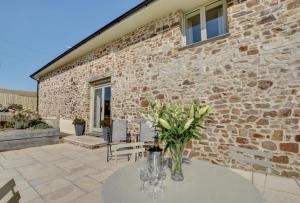 a table with wine glasses and flowers on a patio at 2 Bed in Bishops Nympton oc-barton in Bishops Nympton