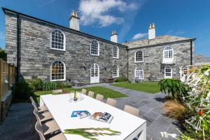 a large stone building with a white table and chairs at 6 Bed in Padstow oc-p00760 in Padstow