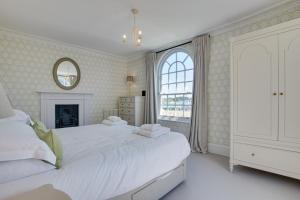 a white bedroom with a large bed and a window at 6 Bed in Padstow oc-p00760 in Padstow