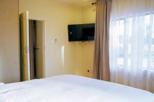 a bedroom with a white bed and a window at Sunderdale in Gweru