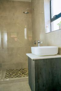 a bathroom with a sink and a shower at Sunderdale in Gweru