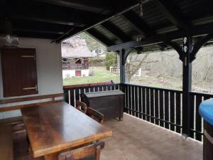 a porch with a wooden table and chairs on a deck at Uskočki san in Sošice