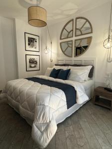 a bedroom with a large white bed and a mirror at Libeccio - Villa Marina in Marina di Andora