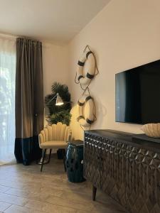 a living room with a flat screen tv and a chair at Libeccio - Villa Marina in Marina di Andora