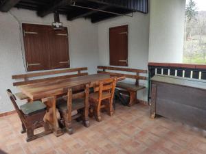 a room with a wooden table and benches and a piano at Uskočki san in Sošice +34 photos
