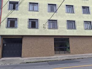 a brick building with several windows on a street at Aconchego in Juiz de Fora