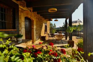 a house with a patio with flowers and a table at Casa Rural La Cordonera in Herguijuela