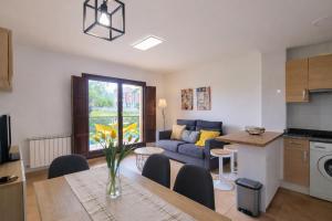 a kitchen and living room with a table and a couch at El Rincon de las Americas in Colombres