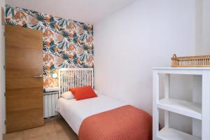 a small bedroom with a bed with a red pillow at El Rincon de las Americas in Colombres +28 photos