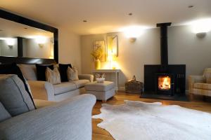 a living room with a couch and a fireplace at Pen-Y-Worlod Cottages in Abergavenny