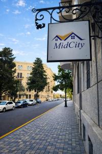 ein Schild an der Seite eines Gebäudes an einer Straße in der Unterkunft MidCity Hotel in Baku