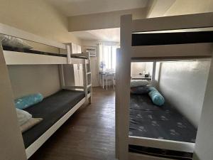 a room with two bunk beds and a table at Orwell Heights-Vista Recto in Manila