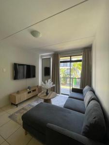 a living room with a blue couch and a tv at Ballito Seasons in Ballito