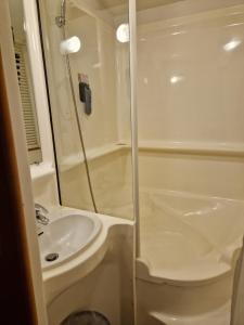 a white bathroom with a shower and a sink at Quick Palace Vannes in Vannes +28 photos