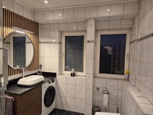 a bathroom with a sink and a washing machine at Komfortable 3-Zimmer- Wohnung in Ratingen +13 photos