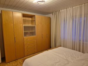 a bedroom with a bed and a cabinet and a window at Komfortable 3-Zimmer- Wohnung in Ratingen