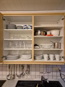 a kitchen cabinet filled with plates and dishes at Komfortable 3-Zimmer- Wohnung in Ratingen