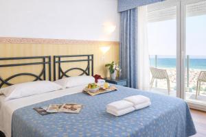 a hotel room with a bed with a view of the ocean at Hotel Regina Fronte Mare in Rimini +25 photos
