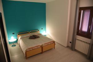 1 dormitorio con 1 cama con 2 lámparas en Green House, en Cavallino di Lecce