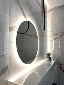 a bathroom with a round mirror on a wall at Apartament Olesno in Olesno +12 photos