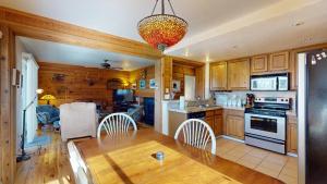 a kitchen with wooden cabinets and a table and a chandelier at Bluff Condo 4015 in Sun Valley