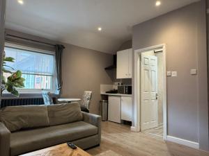 a living room with a couch and a kitchen at The Applewood Regency in Southwell