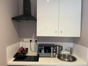 a kitchen with a sink and a microwave at The Applewood Regency in Southwell