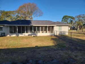 a house with a fence in front of a yard at Manatee River Bungalows - 2 in Bradenton